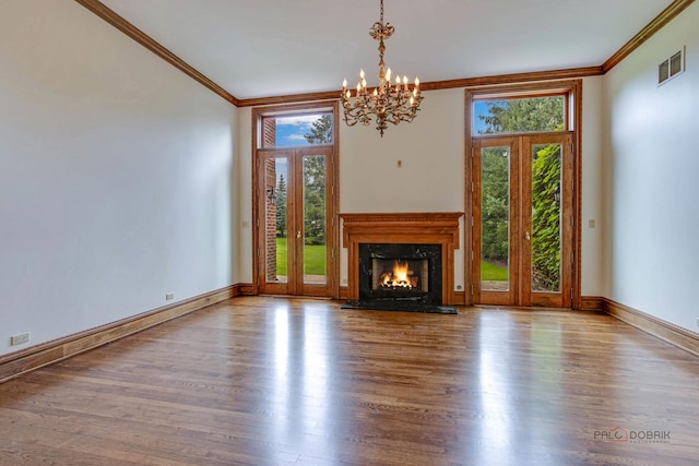 unfurnished living room featuring an inviting chandelier, light wood-type flooring, and crown molding