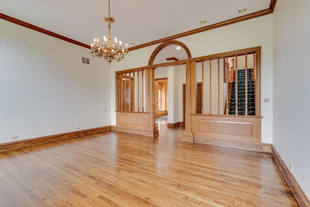 interior space featuring a notable chandelier, light hardwood / wood-style floors, and crown molding