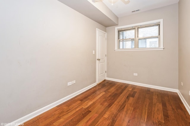 empty room with dark wood-type flooring and ceiling fan