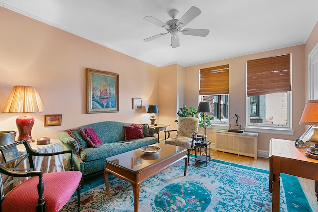 living room with hardwood / wood-style flooring, radiator, ornamental molding, and ceiling fan