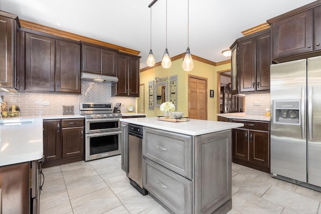 kitchen featuring decorative backsplash, pendant lighting, stainless steel appliances, and ornamental molding