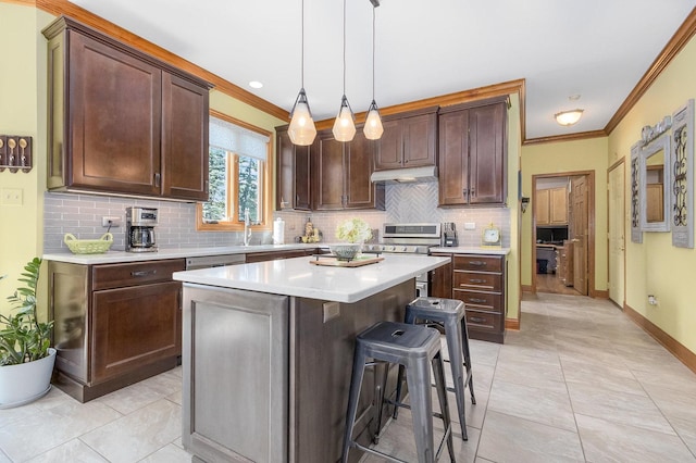 kitchen with a kitchen breakfast bar, crown molding, hanging light fixtures, a kitchen island, and dark brown cabinetry