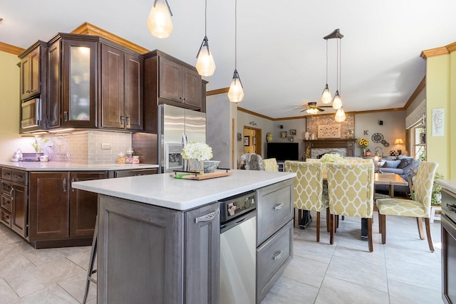 kitchen with ornamental molding, dark brown cabinets, stainless steel appliances, ceiling fan, and decorative light fixtures