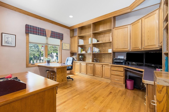 home office with built in desk, ornamental molding, and light hardwood / wood-style flooring