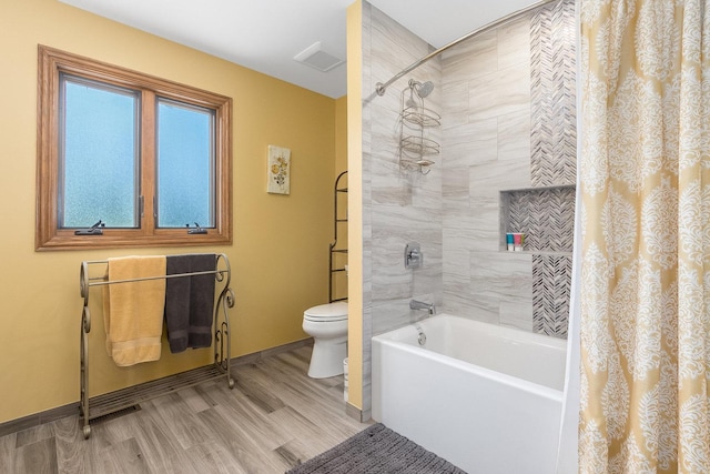 bathroom with hardwood / wood-style floors, shower / bath combo, and toilet