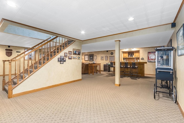 basement with carpet, ornamental molding, and bar