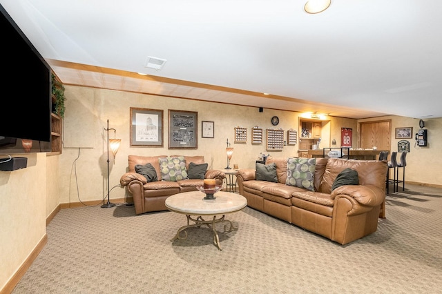 carpeted living room featuring bar area