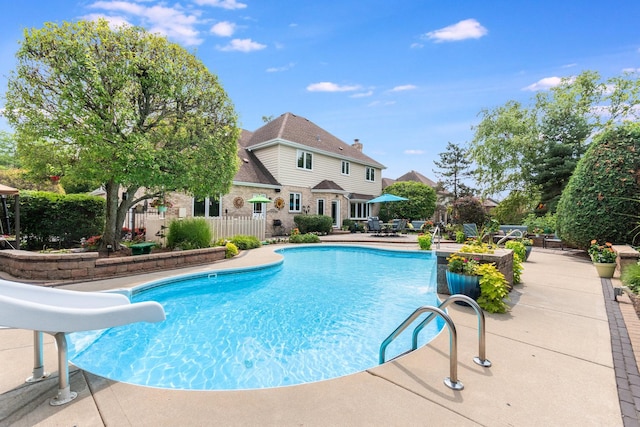 view of pool featuring a water slide and a patio