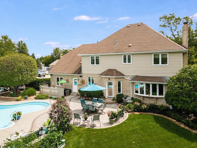 rear view of house featuring a patio area and a lawn