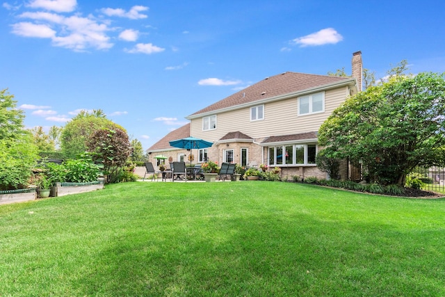 rear view of house featuring a yard