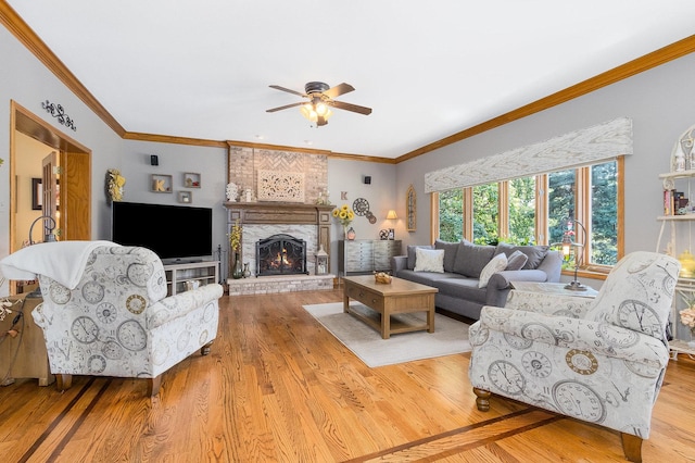 living room with a fireplace, light wood-type flooring, ceiling fan, and ornamental molding