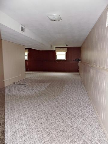 hallway featuring wooden walls