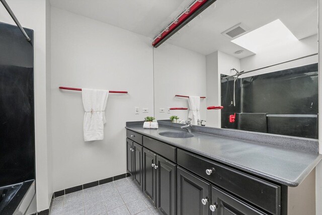 bathroom with a shower, vanity, and tile patterned floors