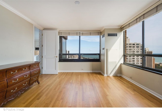 unfurnished bedroom featuring light hardwood / wood-style floors and crown molding