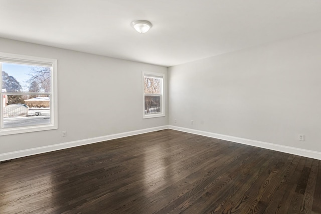 unfurnished room featuring dark hardwood / wood-style floors and plenty of natural light