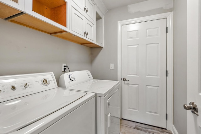 laundry area featuring separate washer and dryer and cabinets