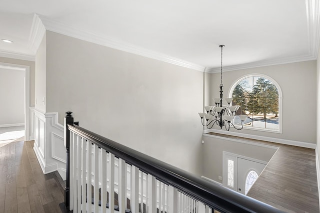 hallway with dark wood-type flooring, crown molding, and a chandelier