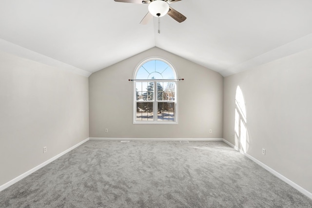 carpeted empty room featuring ceiling fan and vaulted ceiling