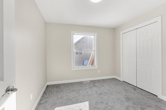 unfurnished bedroom with a closet and light carpet