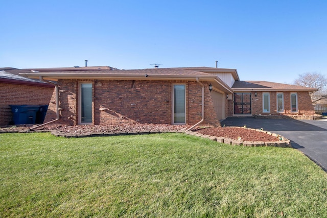 back of property with a lawn and a garage