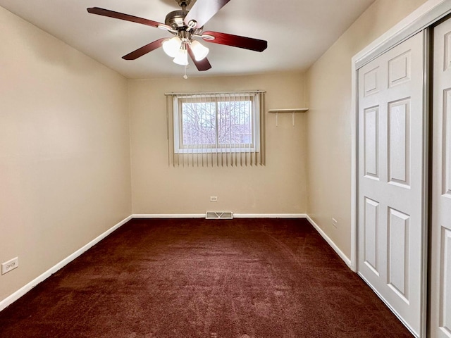 empty room featuring dark colored carpet and ceiling fan