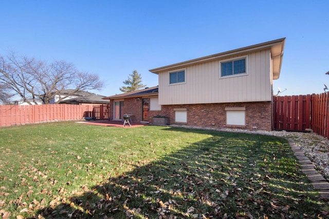 back of property with a lawn and a patio