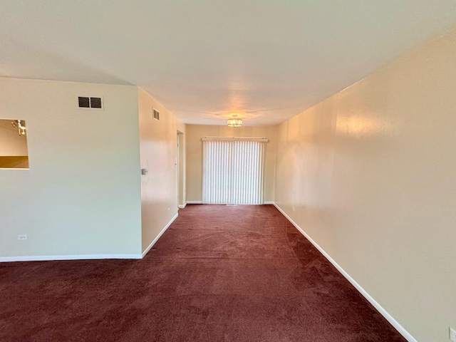 unfurnished room featuring dark colored carpet