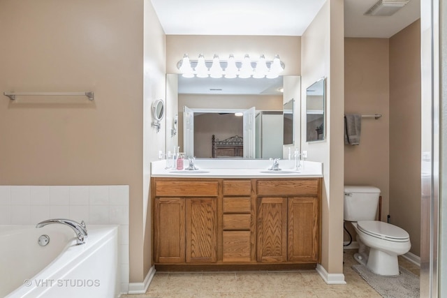 bathroom featuring tile patterned floors, a bathtub, vanity, and toilet