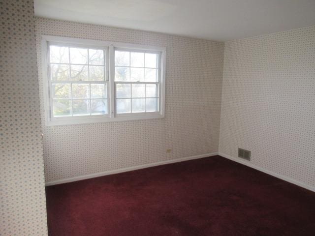 empty room featuring dark carpet