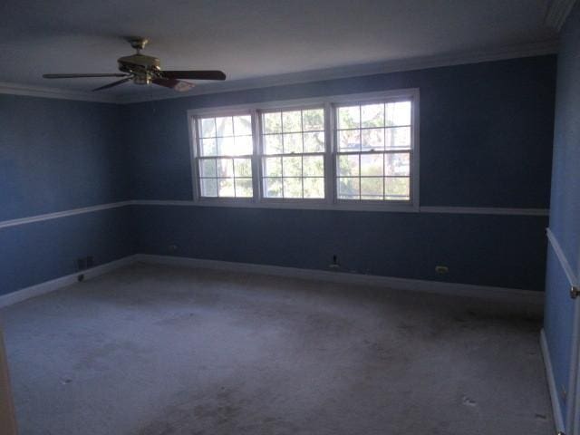 unfurnished room with crown molding, carpet, and ceiling fan