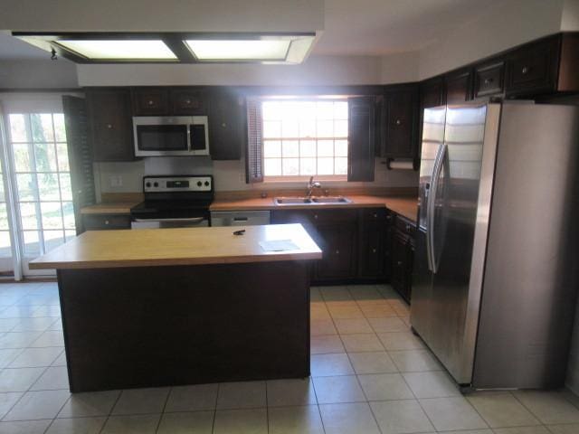 kitchen featuring plenty of natural light, a center island, sink, and appliances with stainless steel finishes