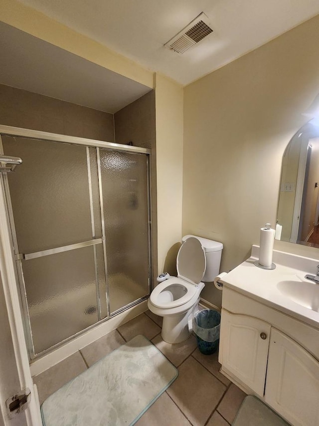 bathroom with tile patterned floors, vanity, toilet, and walk in shower