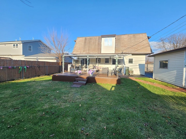 rear view of house featuring a lawn and a deck