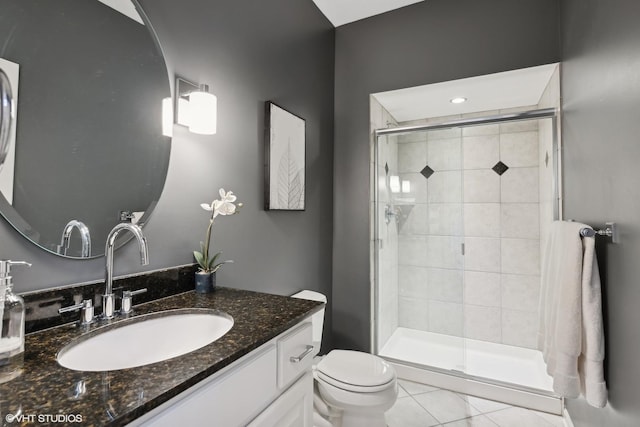 bathroom featuring tile patterned floors, toilet, an enclosed shower, and vanity