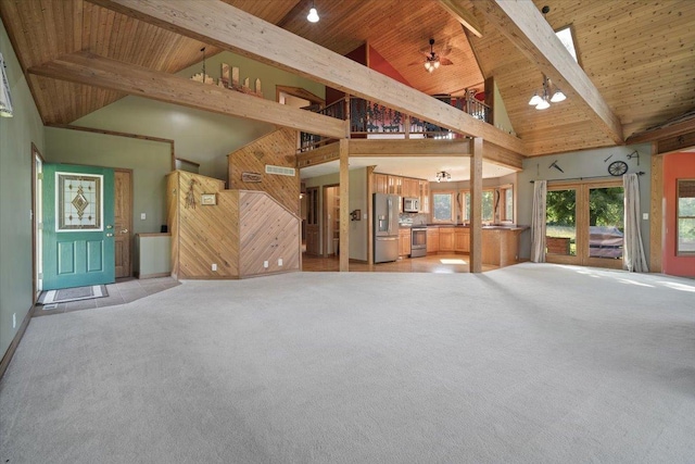 unfurnished living room featuring french doors, light colored carpet, lofted ceiling with beams, wooden walls, and wooden ceiling