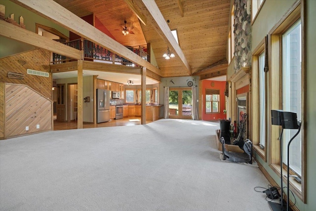 interior space with beam ceiling, visible vents, wood ceiling, light carpet, and wooden walls