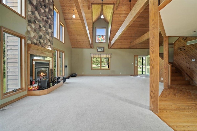 carpeted living room featuring visible vents, beamed ceiling, stairway, and wood ceiling