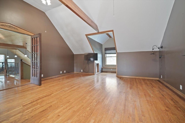 additional living space featuring vaulted ceiling with beams, wood finished floors, and baseboards