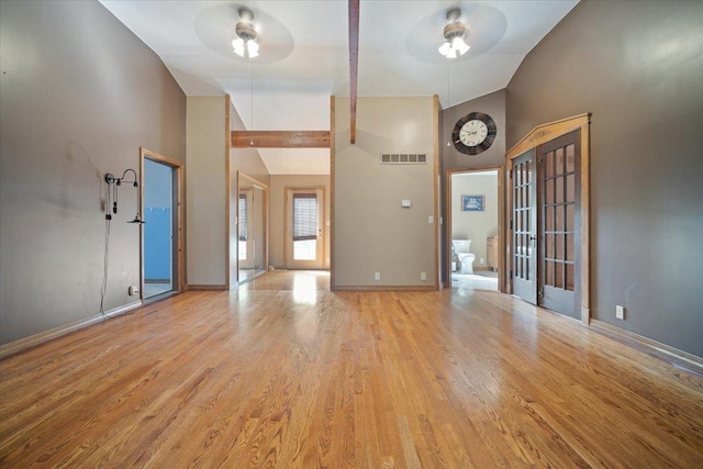 entrance foyer with high vaulted ceiling, light wood-type flooring, visible vents, and baseboards