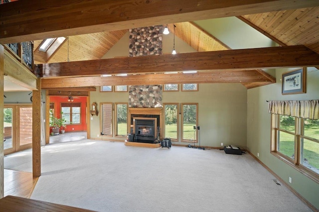 unfurnished living room featuring carpet floors, a wealth of natural light, baseboards, and beam ceiling