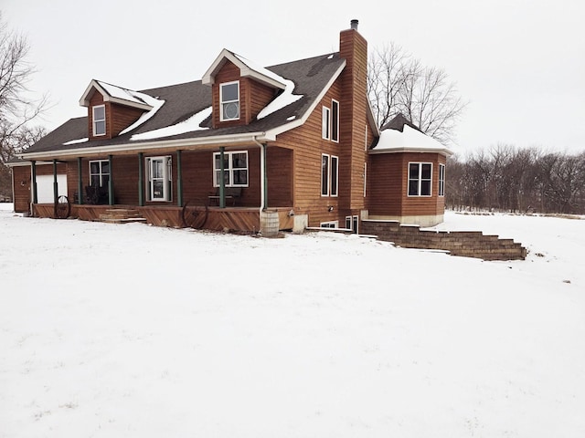 view of front facade featuring covered porch and a chimney