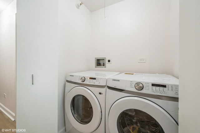 clothes washing area with separate washer and dryer and wood-type flooring