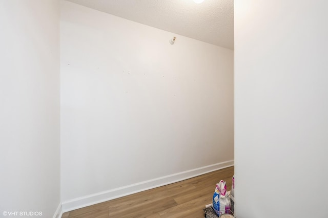 empty room with wood-type flooring and a textured ceiling