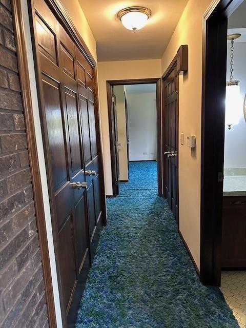 corridor featuring dark colored carpet