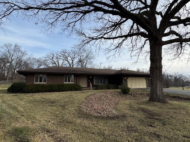 ranch-style home with a garage and a front lawn