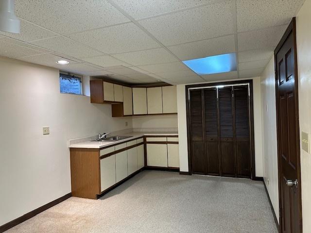 kitchen featuring a paneled ceiling, sink, and cream cabinetry