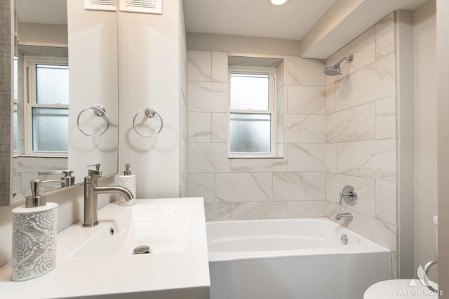 full bathroom featuring vanity, tiled shower / bath combo, and toilet