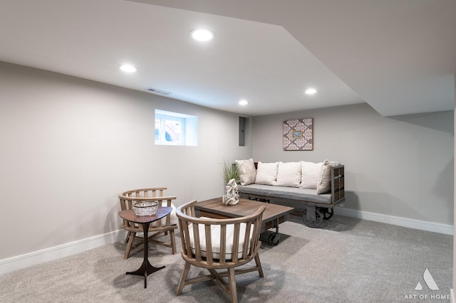 living area featuring light carpet and electric panel