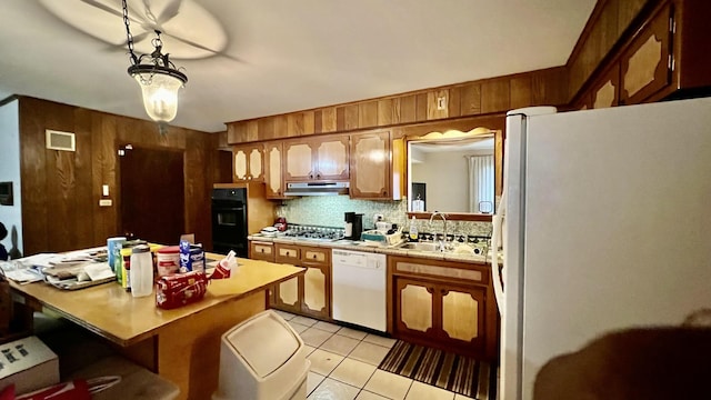 kitchen featuring white appliances, backsplash, sink, hanging light fixtures, and light tile patterned floors