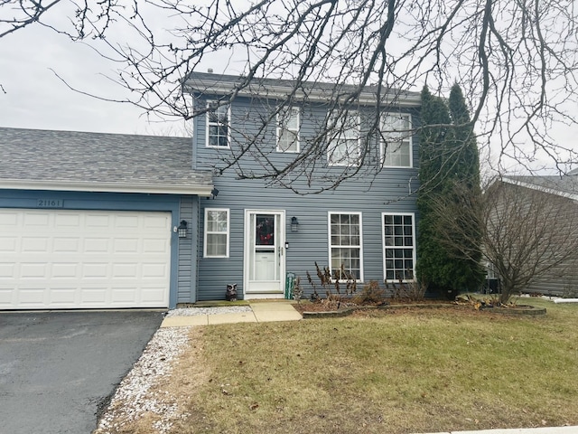 colonial-style house with a garage and a front yard